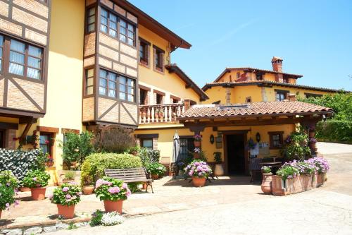 un edificio con un banco y flores en un patio en La Solana Montañesa, en Comillas