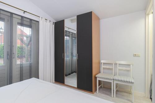 Rinsumageest的住宿－Eysingastate，一间卧室配有镜子、一张床和一把椅子