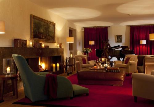 a living room with a fireplace and a piano at Abadia Retuerta LeDomaine in Sardoncillo