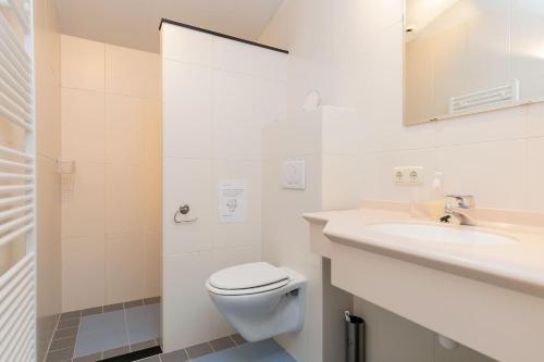 biała łazienka z toaletą i umywalką w obiekcie Eysingastate w mieście Rinsumageest