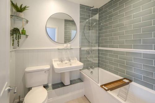 a bathroom with a toilet and a sink and a mirror at The Engine House, 36 Coalford in Ironbridge