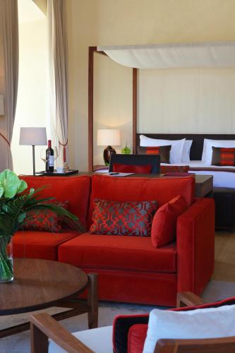 a living room with a red couch and a bed at Abadia Retuerta LeDomaine in Sardoncillo
