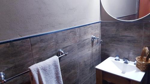 a bathroom with a sink and a mirror at Cabañas del Sol in Tafí del Valle