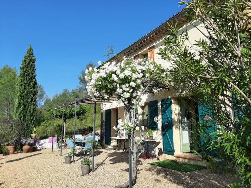 ein Haus mit einem blühenden Baum davor in der Unterkunft Une chambre en Provence in Correns