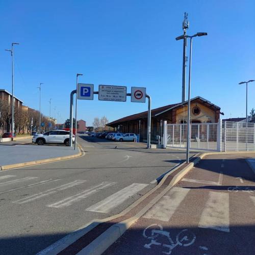 an empty street with cars parked in a parking lot at VIGEVANO LA STAZIONE in Vigevano