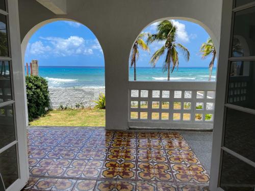 an open door to a room with a view of the ocean at Puesta del Sol Guest House in San Andrés