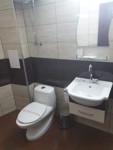 a bathroom with a toilet and a sink at Апартамент Quattro in Dobrich