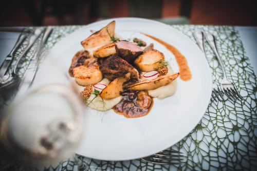 a white plate of food on a table at Tornácos Hotel - Hegykő in Hegykő