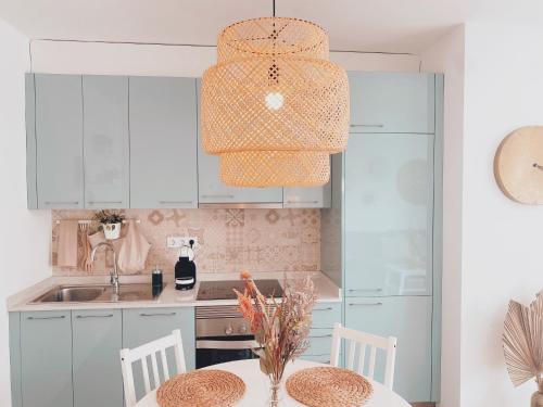 a kitchen with white cabinets and a table with chairs at Casa Rosalia Puerto del Carmen in Puerto del Carmen