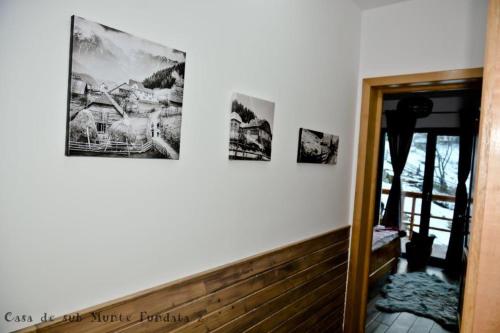 a hallway with three pictures on the wall and a mirror at Casa de sub Munte Fundata2 in Fundata