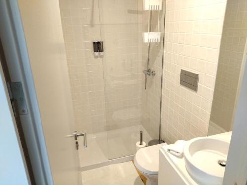 a bathroom with a shower with a toilet and a sink at Lusitania Garden Apartment - Jardim Privado in Porto