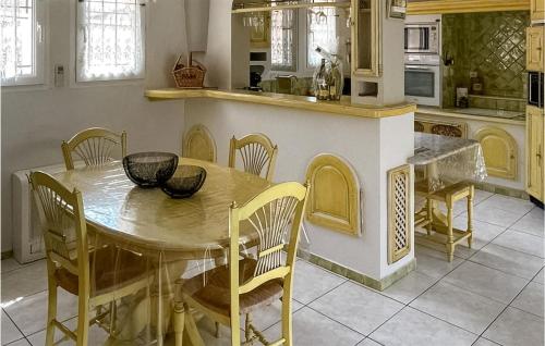 - une cuisine avec une table et des chaises en bois dans l'établissement Cozy Home In Puisserguier, à Puisserguier