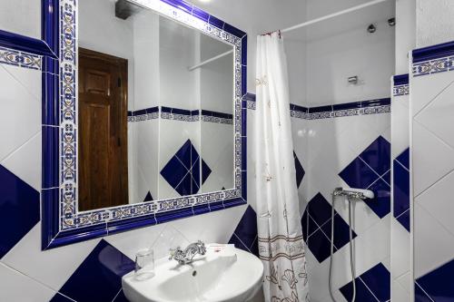 a blue and white bathroom with a sink and a mirror at Casa Rural Del Rio in Alozaina