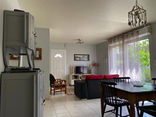une cuisine et un salon avec une table et un canapé dans l'établissement Séjour au cœur de Jard-sur-Mer : Maison avec terrasse et garage près de la plage ! - FR-1-336-125, à Jard-sur-Mer