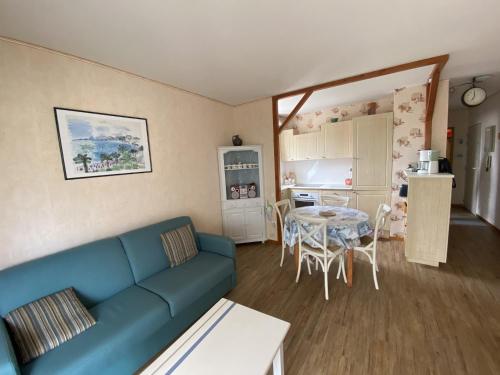 un salon avec un canapé bleu et une table dans l'établissement Appartement à Arcachon: Plages et commerces à pied, balcon, parking, 4 couchages - FR-1-474-193, à Arcachon
