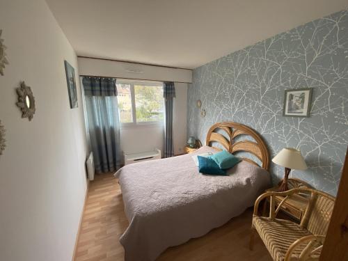 une chambre avec un lit et une chaise dedans dans l'établissement Appartement à Arcachon: Plages et commerces à pied, balcon, parking, 4 couchages - FR-1-474-193, à Arcachon