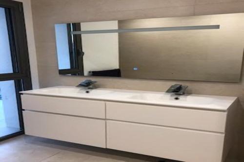 La salle de bains est pourvue d'un lavabo blanc et d'un miroir. dans l'établissement Villa Cenac d architecte vue vignoble proche Bordeaux, à Cénac
