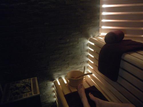a woman sitting on a bench with a cup of coffee at Zeeuws Ontspannen Bed & Wellness in Middelburg