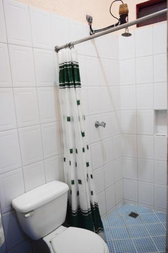 a bathroom with a toilet and a shower curtain at Hotel Realidad in Guatemala