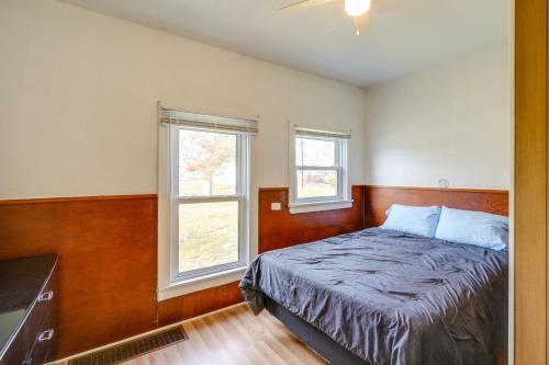 a bedroom with a bed and two windows at Cedar Rapids Vacation Home Near Downtown District! in Cedar Rapids