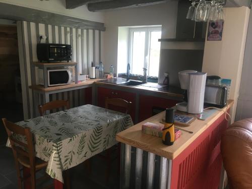 une petite cuisine avec une table et un micro-ondes dans l'établissement La Vannerie, à Roézé-sur-Sarthe