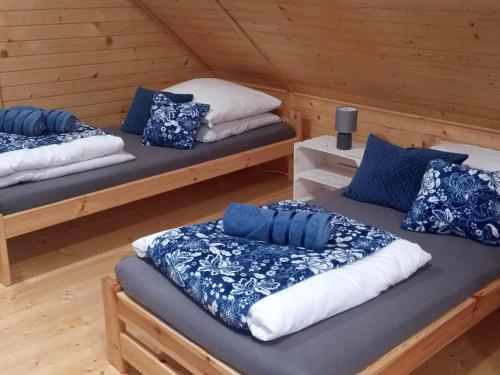 een kamer met 2 bedden in een houten hut bij Pokoje Amelia in Zator