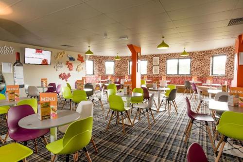 a dining room with tables and chairs in a cafeteria at Birchington Vale entire holiday home in Westgate-on-Sea