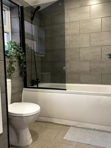 a bathroom with a toilet and a bath tub at Newly refurbished city house with Hot Tub in Lincoln
