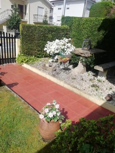 a garden with two potted flowers and a bench at Alojamento Local Casa Veras in Vila Real