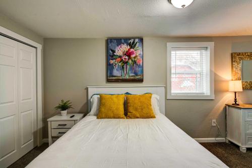 1 dormitorio con 1 cama blanca grande con almohadas amarillas en Cozy Ogden Cottage 1 Mi to Downtown!, en Ogden