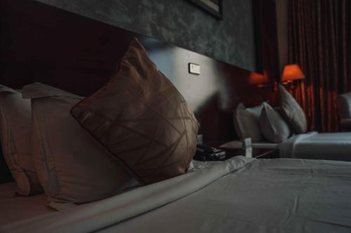 a bedroom with a bed with a pillow and a chair at Sidra International Hotel in Addis Ababa