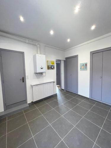 une chambre vide avec deux portes et du carrelage dans l'établissement Appartement de la laverie, à La Tour-du-Pin