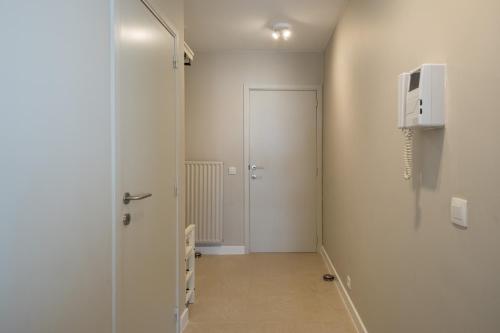 un pasillo con una puerta que conduce a una habitación en Royal Bayaux with free private parking, en Knokke-Heist