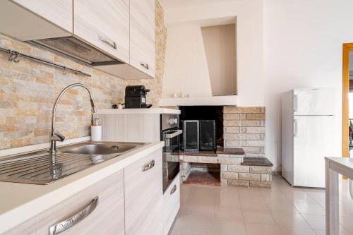 Una cocina blanca con fregadero y refrigerador. en "Le Camere di Beppe", Ampio e Luminoso Appartamento a Lecce, en Lecce