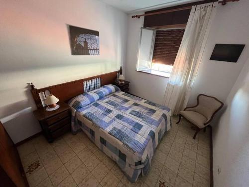 1 dormitorio con 1 cama, 1 silla y 1 ventana en Estupenda Casona Rural Montañesa, en Trasvia