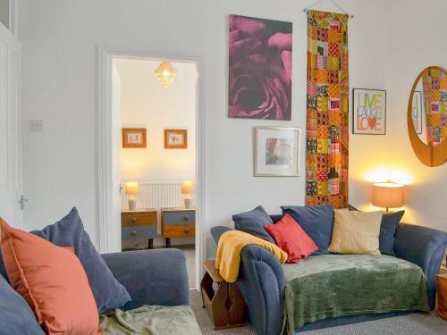 een woonkamer met een blauwe bank en kleurrijke kussens bij Brincliffe Landing - Uk42799 in Bridlington