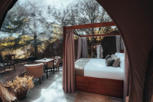 Noctis Hotel في سُريا: غرفة نوم مع سرير المظلة وطاولة