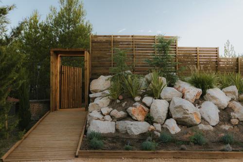 a wooden pathway leading to a garden with rocks at Noctis Hotel in Soria