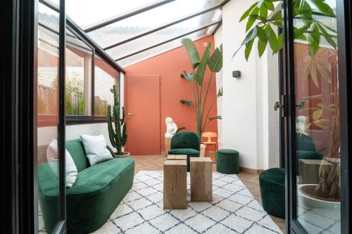 un salon avec un canapé vert et des plantes dans l'établissement La Maison de Jean by Maison Bacou, à Carcassonne