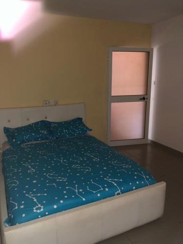 een slaapkamer met een bed met een blauw dekbed bij Appart F2 plein centre 