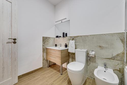 a bathroom with a toilet and a sink at ARI Central Grand Apartments - Luxurious Stay in Arad