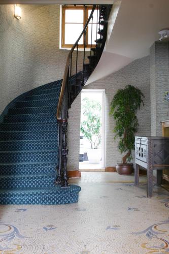 a spiral staircase in a room with a blue tile floor at Hotel Meslay Republique in Paris