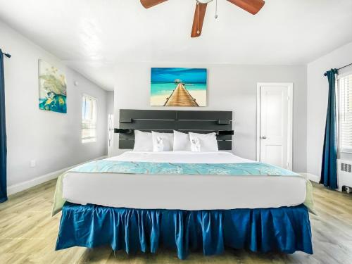 a bedroom with a large white bed with blue sheets at Ocean Villas in Hollywood