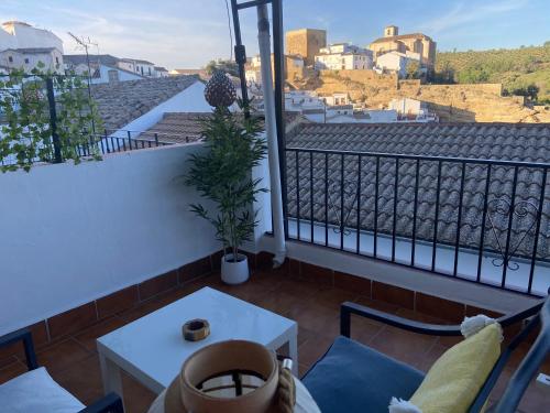 a balcony with a table and a view of a city at Casa del Mar a la Sierra in Setenil