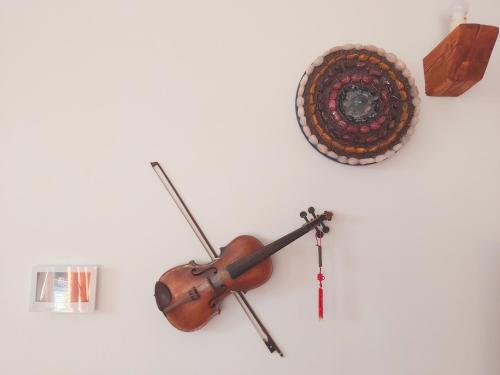 a violin and a target on a white wall at Apartman Brina in Kanfanar