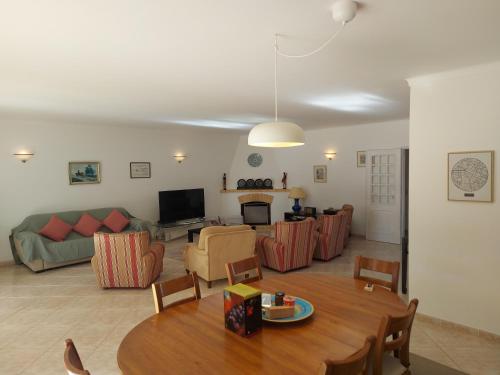 a living room with a table and a couch at The Pinewood Villa in Vilamoura
