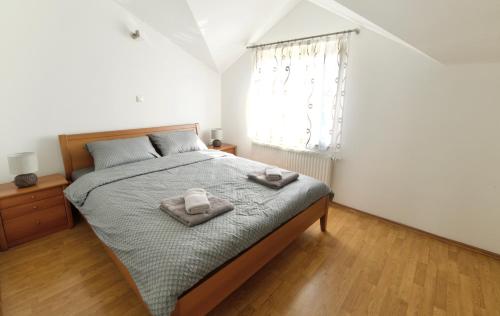 a bedroom with a bed with two towels on it at Relax House Nizic in Dražice