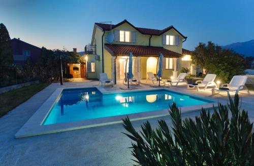 - une piscine en face d'une maison dans l'établissement Relax House Nizic, à Dražice
