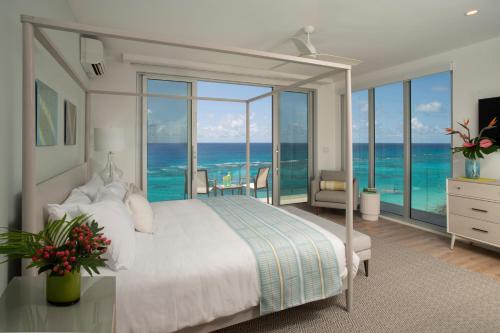 a bedroom with a bed with a view of the ocean at Azura Bermuda in Bermuda