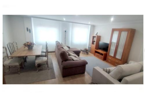a living room with a couch and a dining room table at El Balcón del Campillín in Oviedo